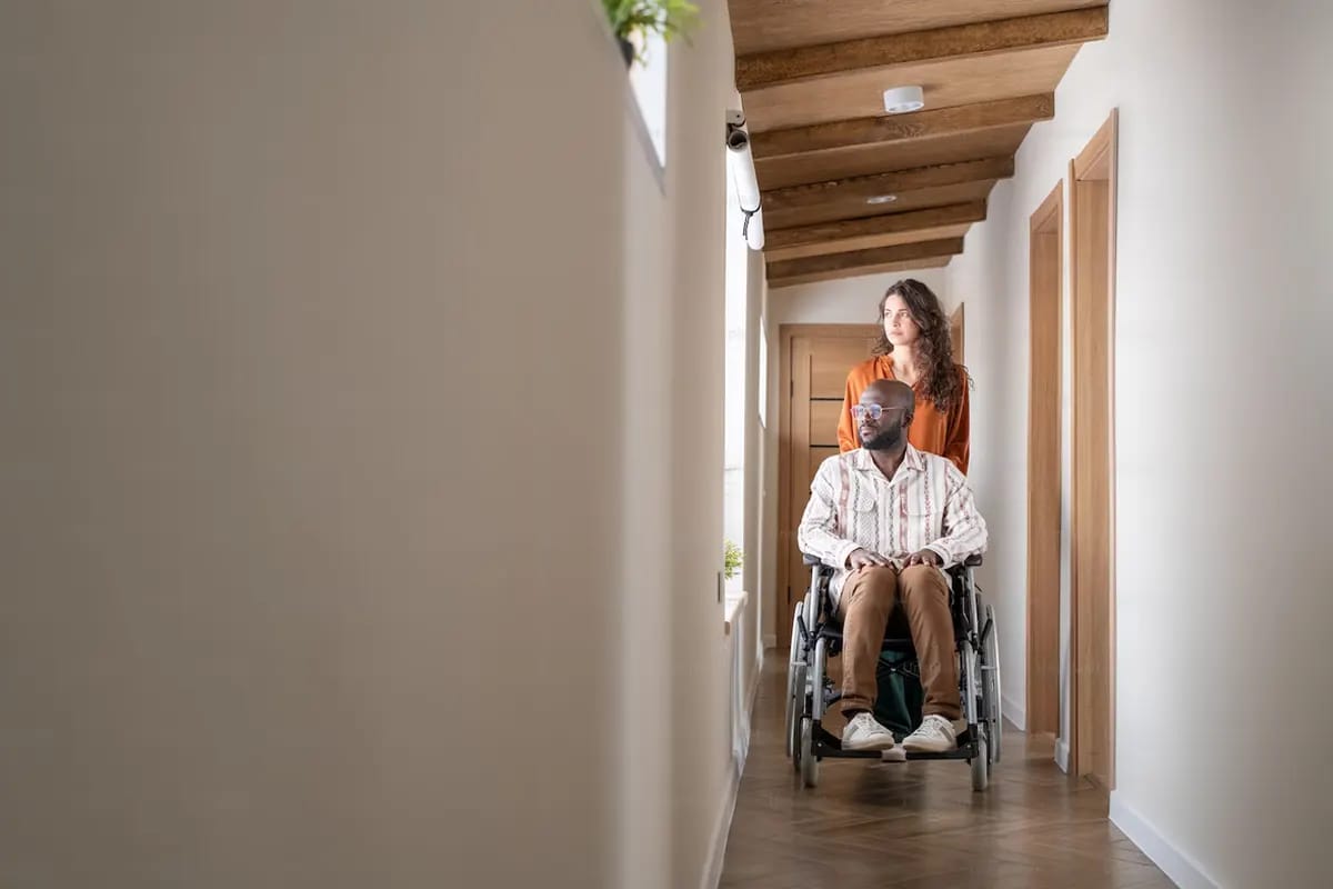 A support worker assisting a wheelchair user at home
